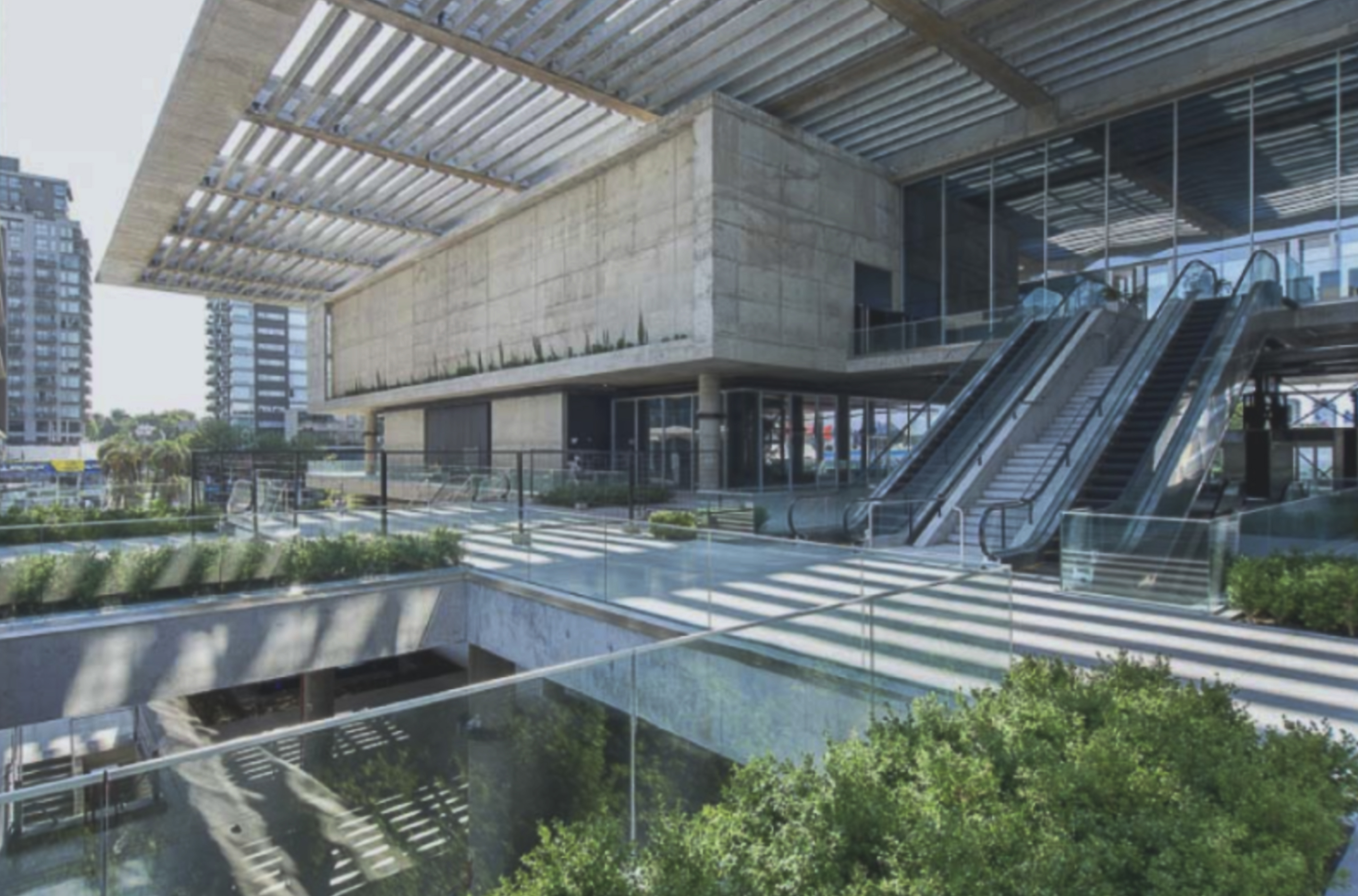 Complejo Al Río: terrazas con vegetación y escaleras mecánicas.